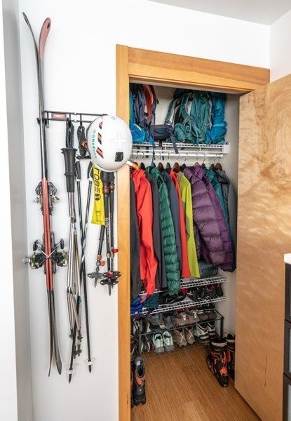 Åpen skibod med ski, staver, hjelmer og fargerike klær